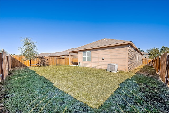 rear view of property with a yard and central air condition unit