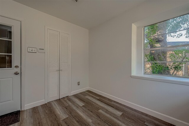 unfurnished bedroom with a closet and hardwood / wood-style floors