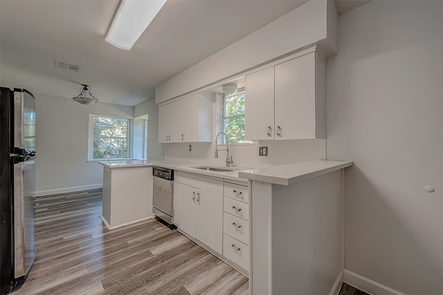 kitchen featuring kitchen peninsula, stainless steel appliances, a healthy amount of sunlight, and sink