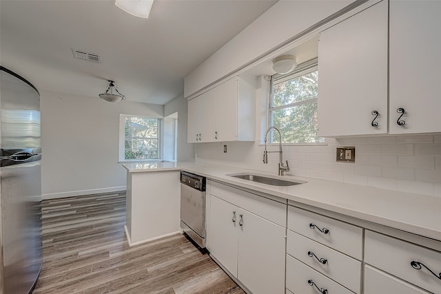 kitchen with sink, stainless steel appliances, light hardwood / wood-style flooring, backsplash, and white cabinets