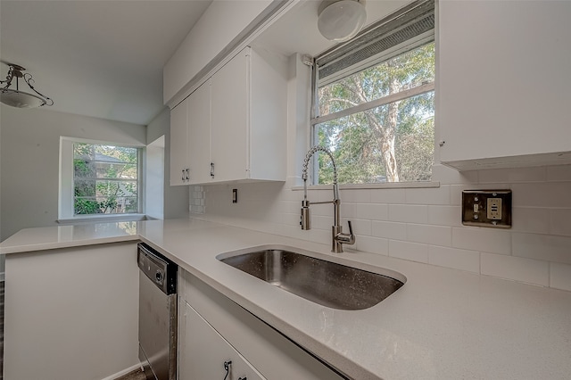 kitchen featuring dishwasher, backsplash, sink, kitchen peninsula, and white cabinetry