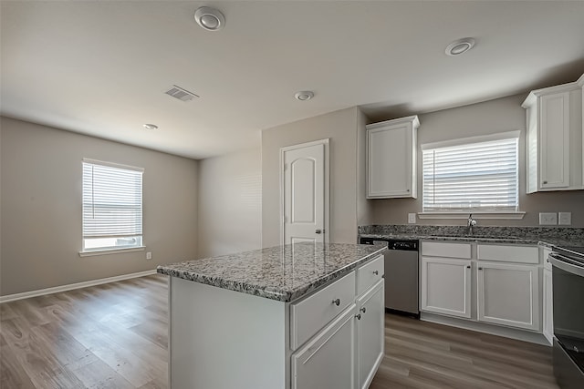 kitchen featuring a kitchen island, appliances with stainless steel finishes, wood-type flooring, and plenty of natural light