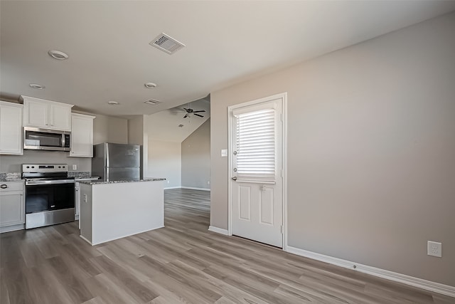 kitchen with a kitchen island, appliances with stainless steel finishes, light hardwood / wood-style flooring, and white cabinets