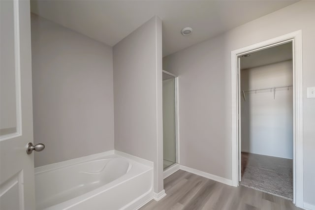 bathroom with hardwood / wood-style flooring and independent shower and bath