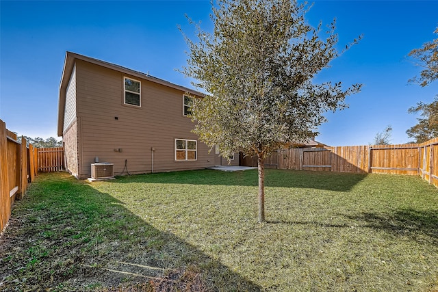 rear view of property featuring a patio, a lawn, and central AC unit