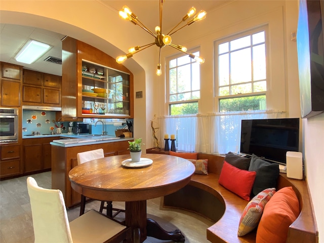 tiled dining area featuring sink and a chandelier