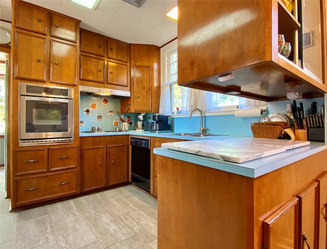 kitchen with dishwasher, stainless steel oven, kitchen peninsula, backsplash, and sink