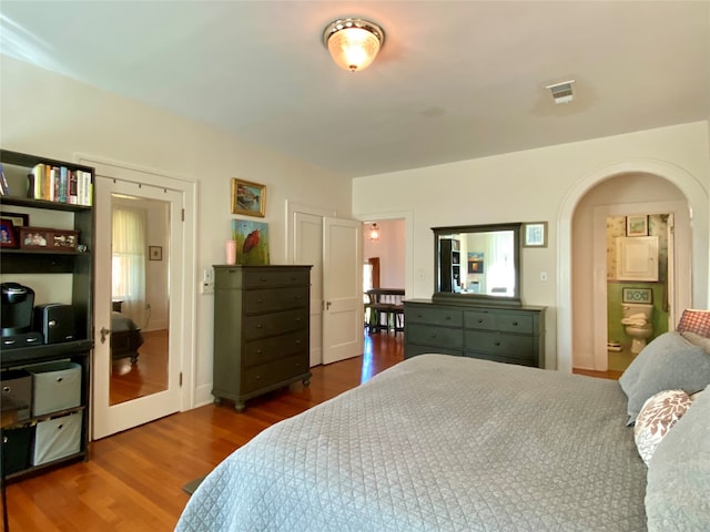 bedroom featuring hardwood / wood-style floors and ensuite bath