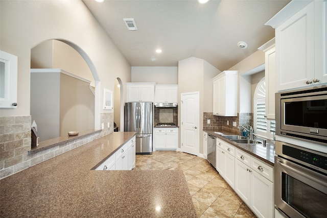 kitchen featuring backsplash, appliances with stainless steel finishes, sink, and white cabinets