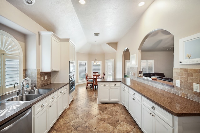 kitchen featuring a wealth of natural light, sink, kitchen peninsula, and backsplash