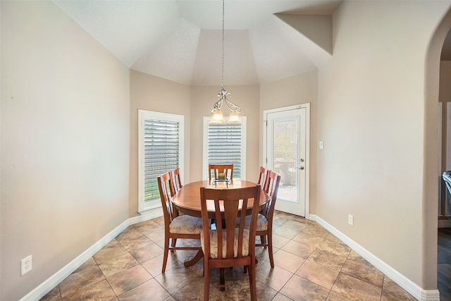 dining area with high vaulted ceiling and a notable chandelier