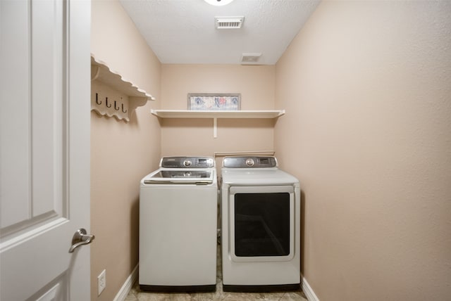 washroom featuring independent washer and dryer and a textured ceiling