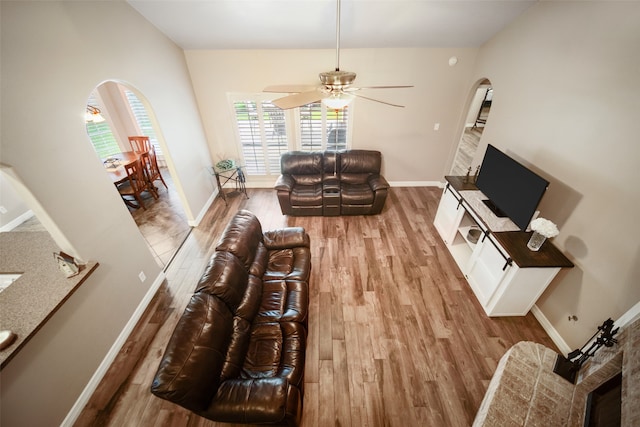 living room featuring lofted ceiling, light hardwood / wood-style floors, and ceiling fan