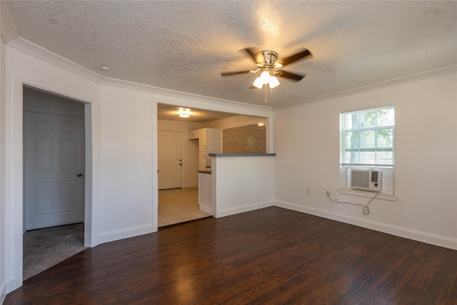 empty room featuring ceiling fan, a textured ceiling, ornamental molding, and dark hardwood / wood-style floors