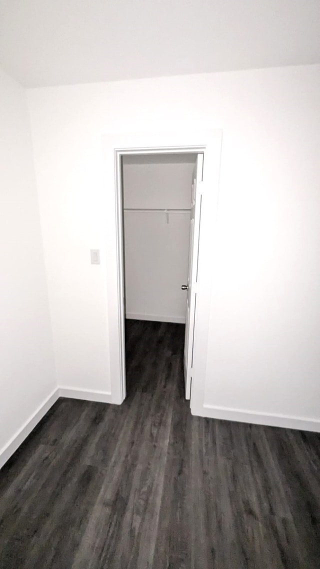 unfurnished room with dark wood-type flooring