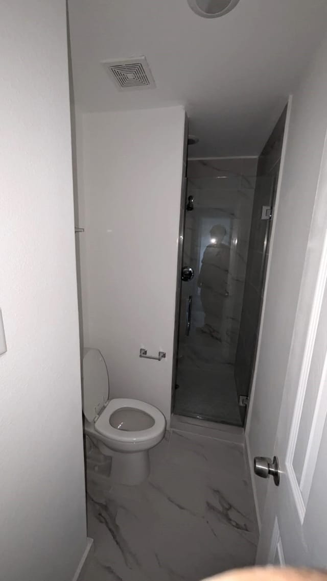 bathroom with toilet and an enclosed shower