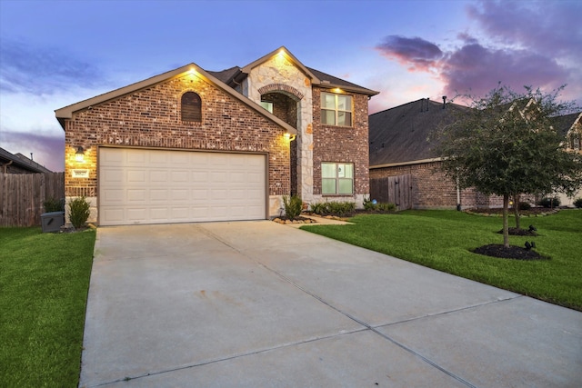 front of property with a garage and a lawn