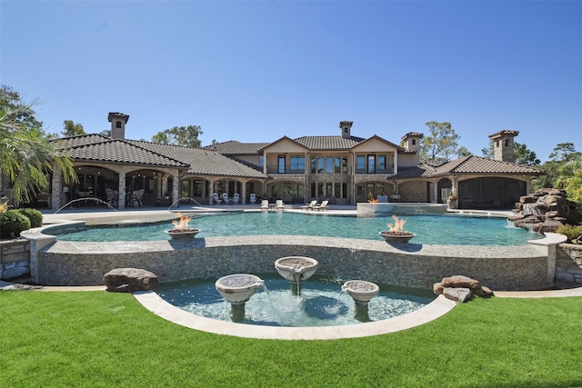 view of pool with pool water feature and a lawn