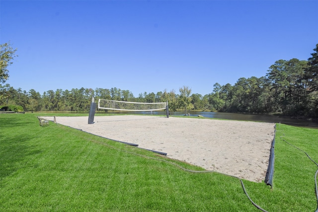 view of home's community featuring a yard, volleyball court, and a water view