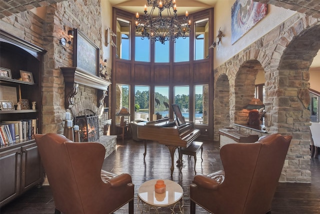 27918 Hansons Ct, Spring, TX 77386 - living area featuring a fireplace, a chandelier, hardwood / wood-style flooring, a towering ceiling, and arched walkways