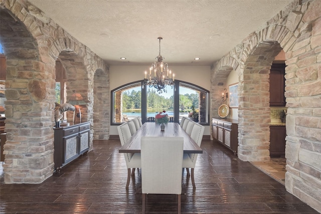 27918 Hansons Ct, Spring, TX 77386 - dining space featuring a chandelier, dark wood finished floors, a textured ceiling, baseboards, and arched walkways
