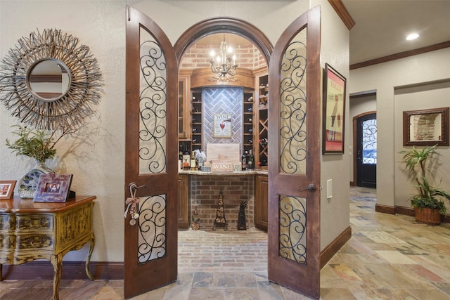 27918 Hansons Ct, Spring, TX 77386 - wine cellar with ornamental molding, baseboards, a textured wall, arched walkways, and light stone finish flooring