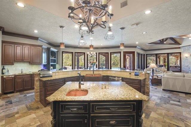 kitchen featuring sink, an island with sink, and pendant lighting