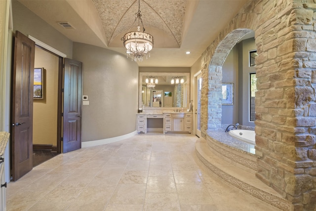 bathroom with a bathing tub, lofted ceiling, vanity, and an inviting chandelier