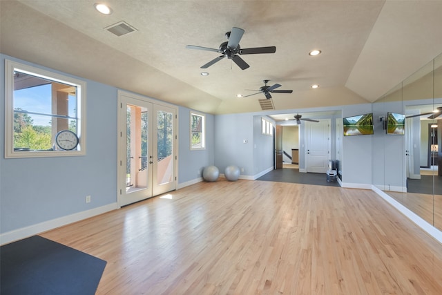 exercise area featuring lofted ceiling, a textured ceiling, and hardwood / wood-style flooring