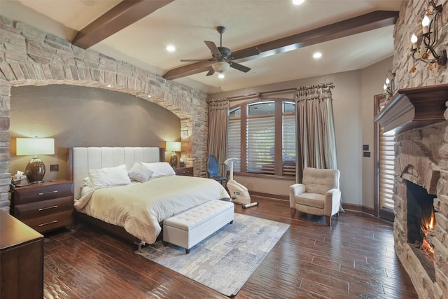 bedroom with beam ceiling, a fireplace, dark hardwood / wood-style floors, and ceiling fan