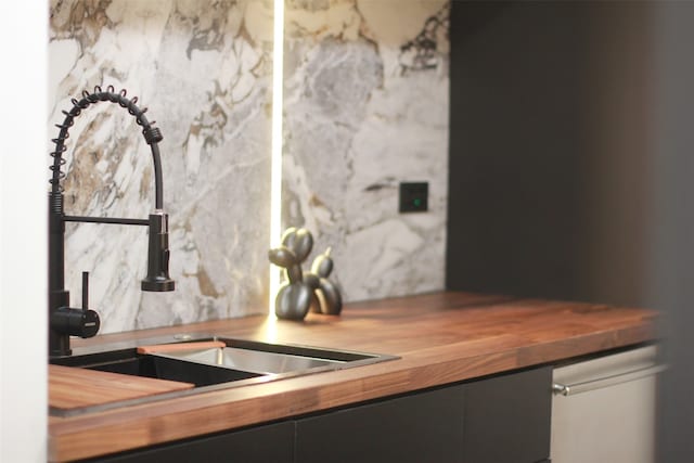 interior details with decorative backsplash, butcher block counters, and sink