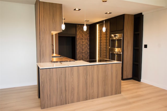 kitchen featuring kitchen peninsula, light wood-type flooring, pendant lighting, black electric stovetop, and stainless steel double oven