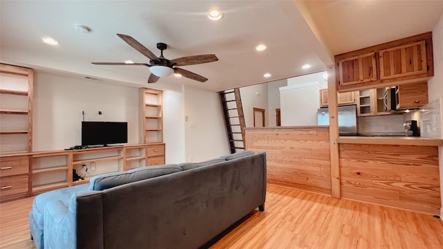 living room with light hardwood / wood-style flooring and ceiling fan