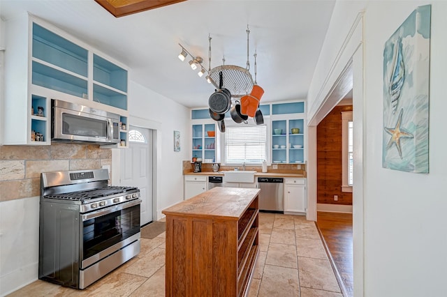 kitchen featuring tasteful backsplash, sink, white cabinets, and appliances with stainless steel finishes