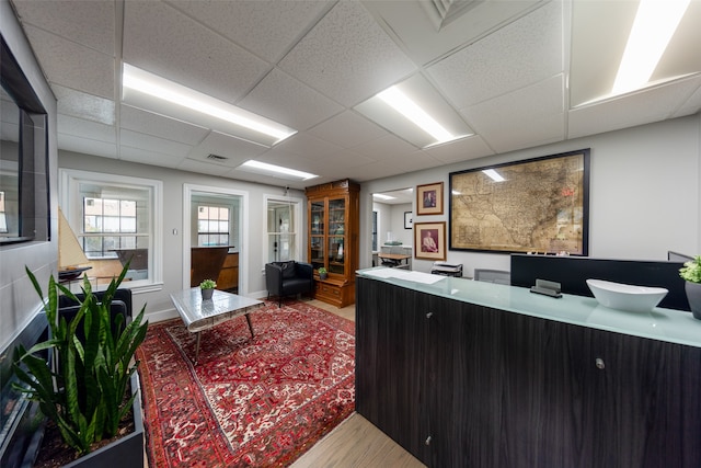 office space featuring a drop ceiling and hardwood / wood-style flooring