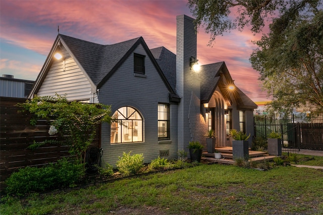 back house at dusk featuring a yard