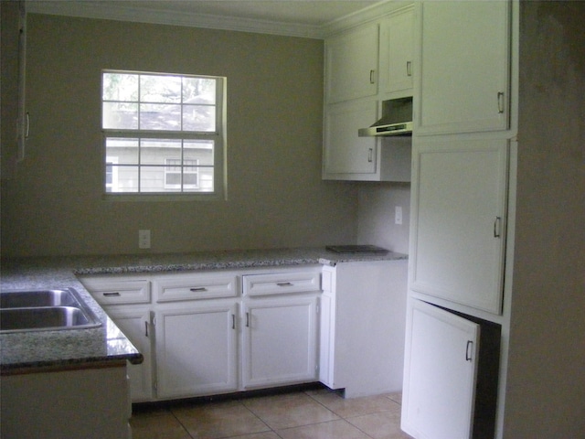 kitchen featuring stone counters, light tile patterned flooring, white cabinets, range hood, and crown molding