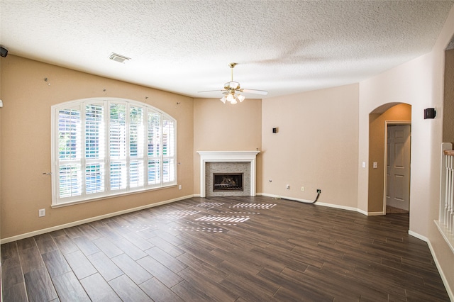 unfurnished living room featuring a textured ceiling, ceiling fan, and dark hardwood / wood-style flooring