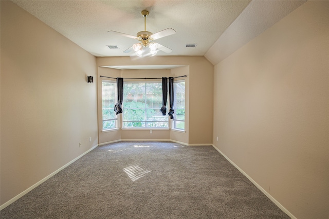 carpeted spare room with a textured ceiling, ceiling fan, and vaulted ceiling