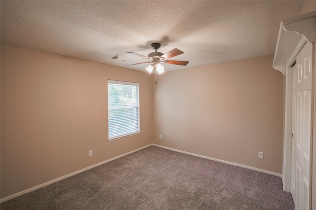 carpeted spare room featuring ceiling fan and a textured ceiling