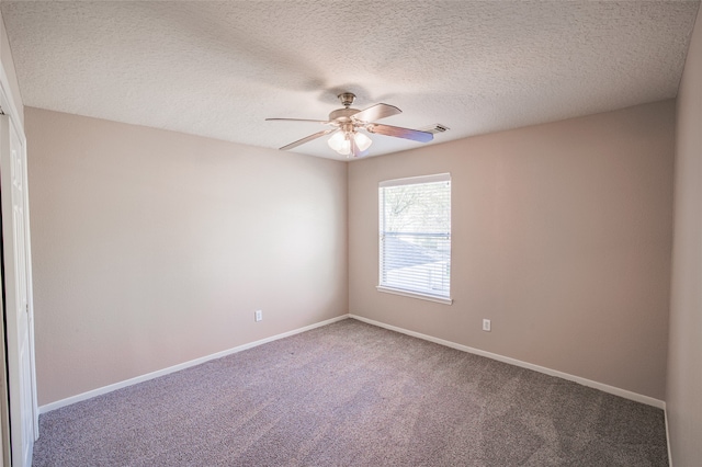 carpeted spare room featuring a textured ceiling and ceiling fan