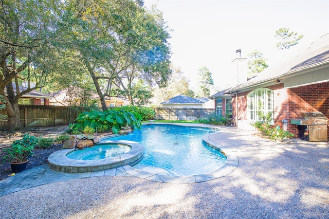 view of swimming pool with a patio, an in ground hot tub, and grilling area