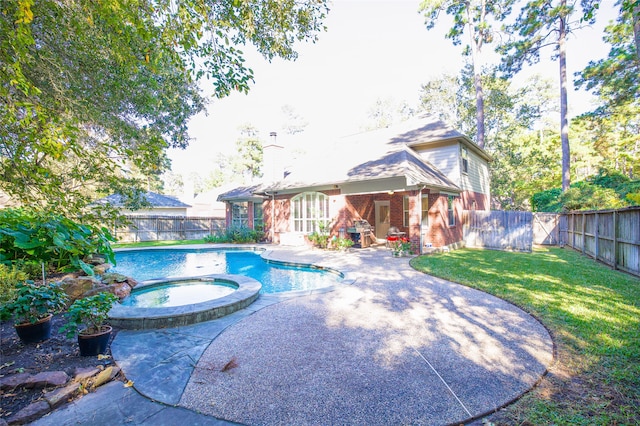 view of swimming pool featuring an in ground hot tub, a yard, and a patio area