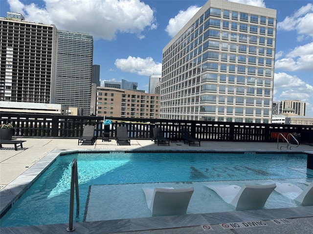 community pool with a city view and a patio area