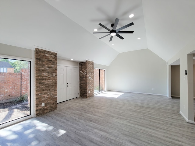 unfurnished living room with ceiling fan, high vaulted ceiling, and light wood-type flooring