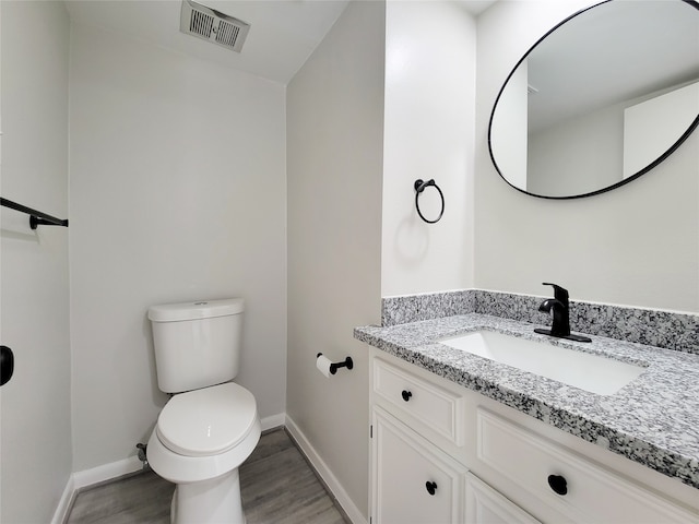 bathroom featuring vanity, hardwood / wood-style flooring, and toilet