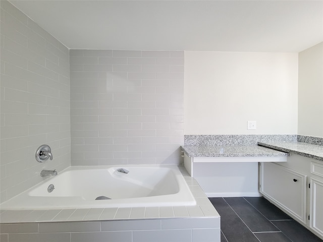 bathroom with vanity, a relaxing tiled tub, and tile patterned floors