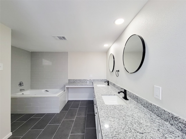 bathroom with vanity, tiled bath, and tile patterned floors