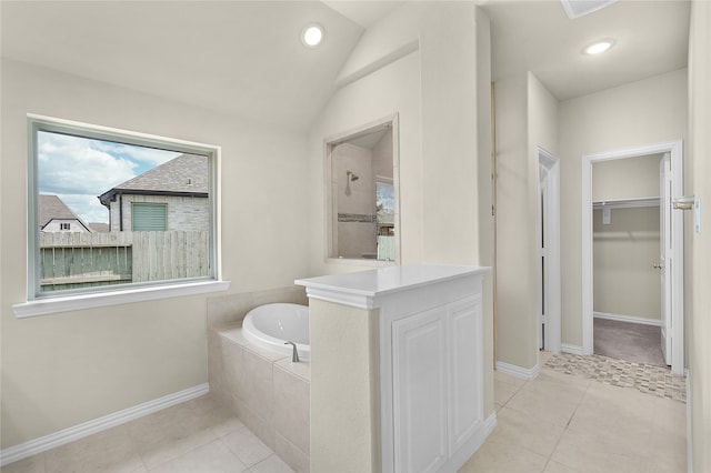 bathroom with tile patterned floors, vaulted ceiling, and separate shower and tub