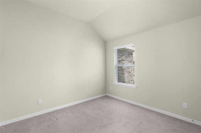 empty room featuring lofted ceiling and carpet floors